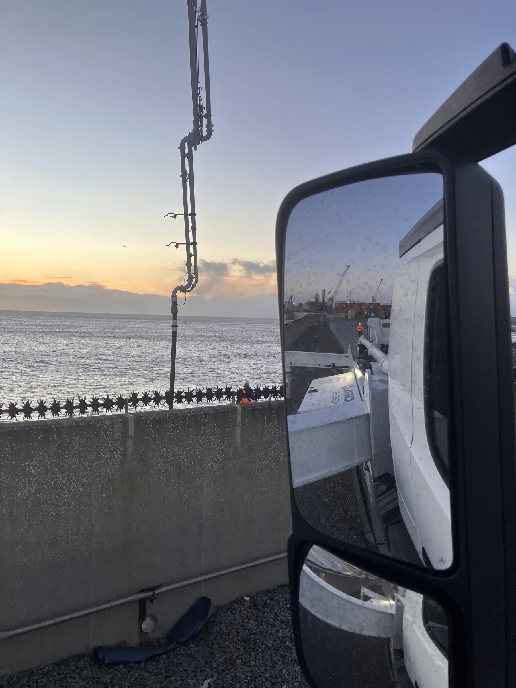 View from Bailey's concrete pump beside the sea wall at Port of Sunderland, showing the boom extending towards the repair area.