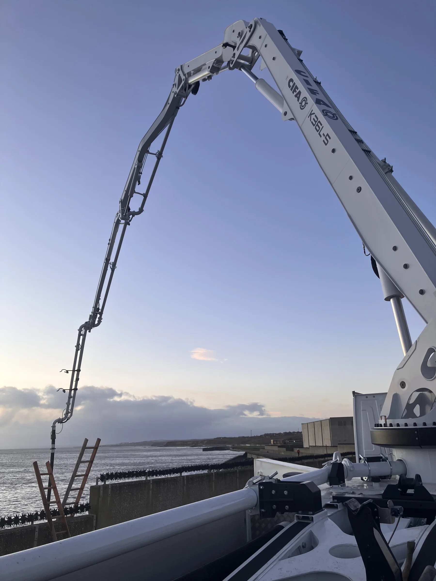 36m CIFA concrete pump boom extended over the coastal wall at Sunderland Docks