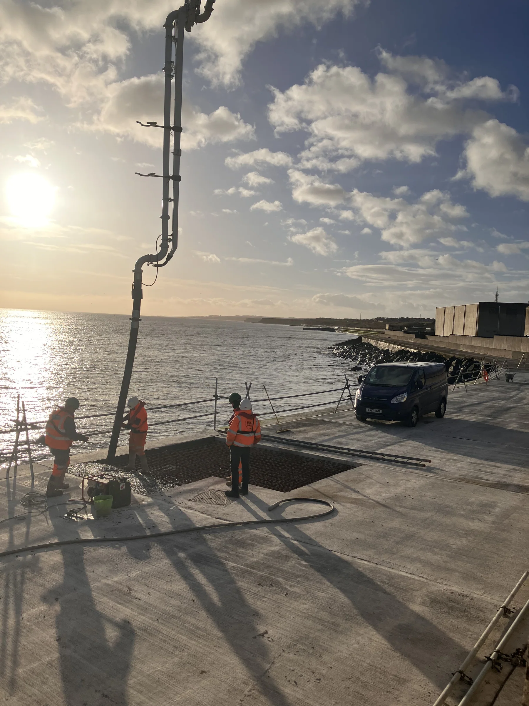 Concrete pump delivery hose extended towards coastal repair works beside the North Sea at Sunderland